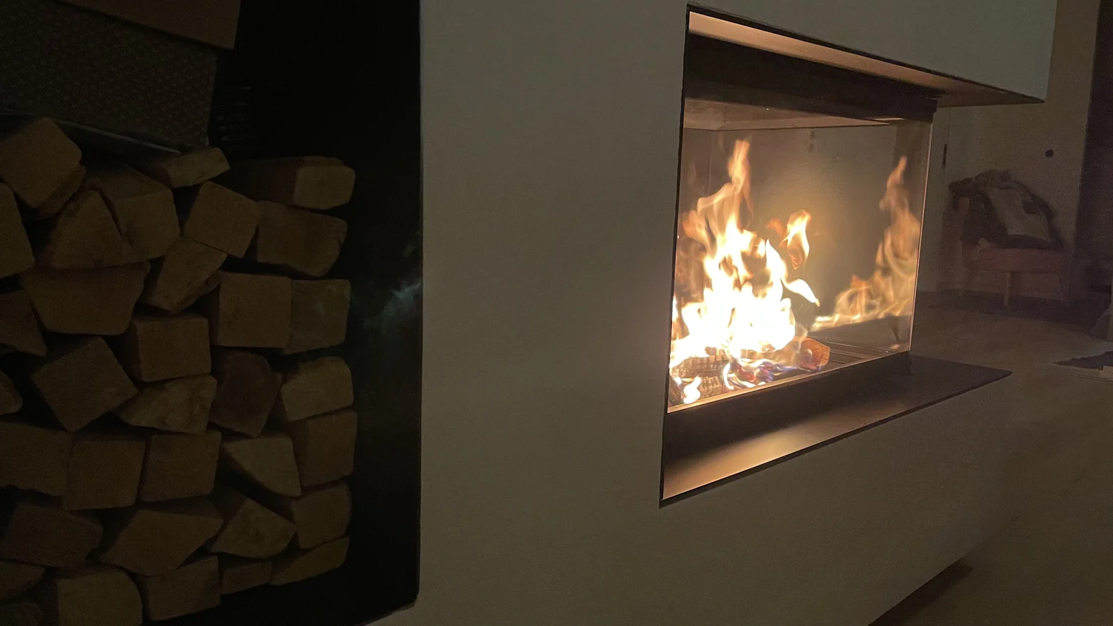 Holzlager aus geöltem Rohstahl neben der brennenden Feuerstelle