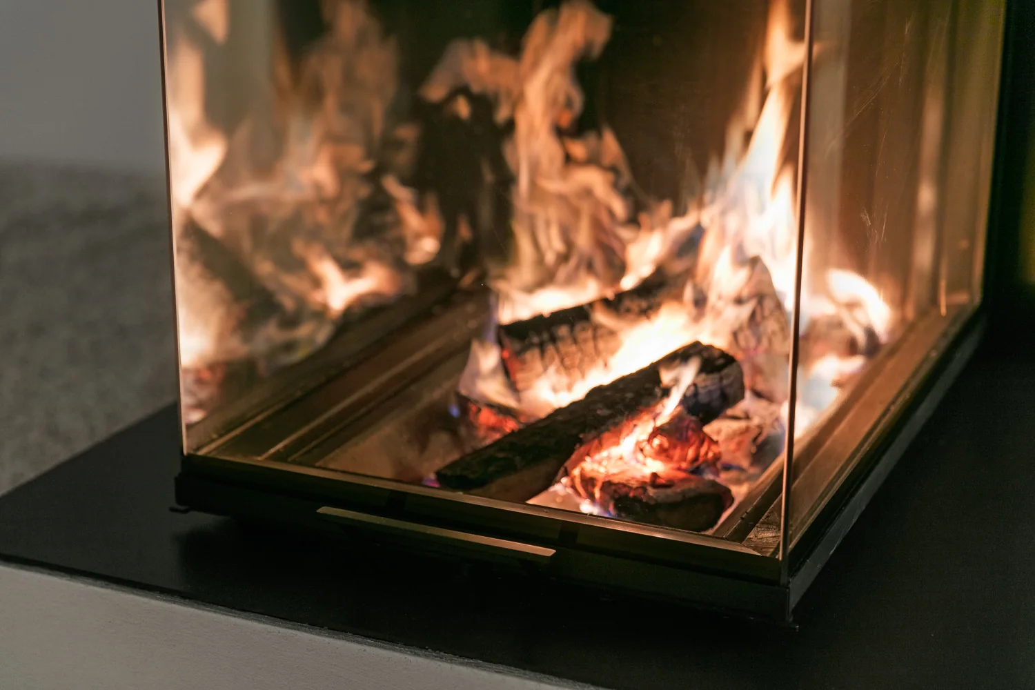 Detailaufnahme des Feuers hinter der Eckverglasung des HOXTER Kamins