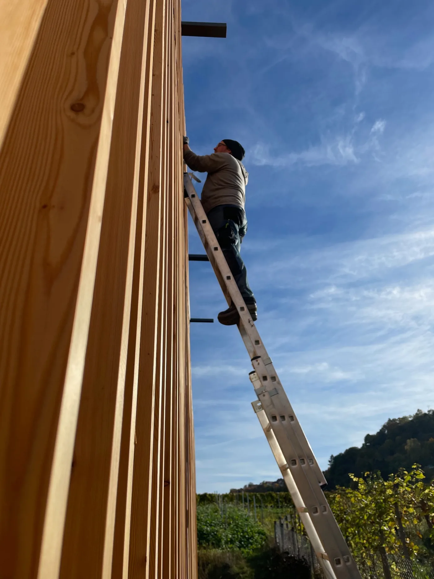 Montage eines Edelstahlschornsteins an einer Holzfassade